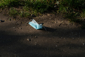 Disposable personal protective equipment discarded in public places (supermarkets parks forests). New type of garbage (masks gloves) during COVID-19 pandemic. Mass environmental pollution by plastic