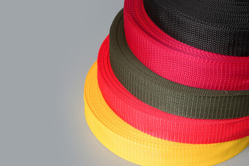 rolls of textile tape on gray background. color tape production.