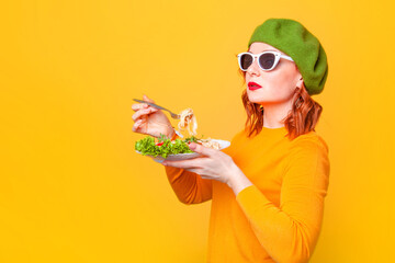 woman in green beret eats pasta on beige background in studio