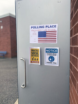 Polling Place Door With Signs Reminding Voters To Wear A Mask And To Social Distance.