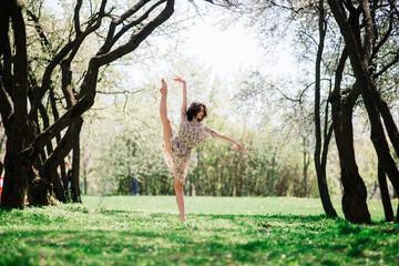 Woman ballerina in blooming garden. pink. ballet. portrait of dancing girl outdoor. fashion and style