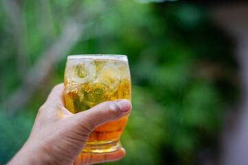 
A glass of cold beer in the hand And blurred backgrounds