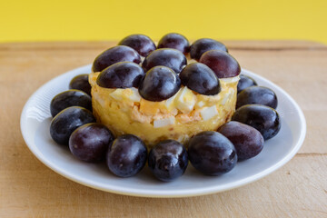 The legendary Tiffany layered salad with grapes, chicken and cheese on the yellow background.