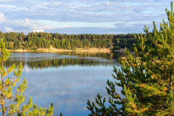 Emerald Lake with textural clouds, sandy mountains and forest. View from a high mountain.