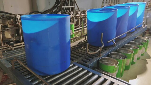 Blue barrels on an automated line in a factory. The process of colorization in the factory