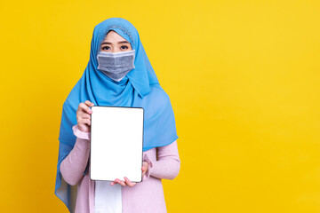 Asian muslim woman in medical mask Coronavirus pandemic disease showing tablet isolate background. COVID-19 virus epidemic outbreak.