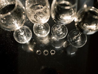 Full Glasses with champagne on the table. Rings for bride and groom. Festive table setting. Wedding decor. Table setting in fine art style,selective and soft focus