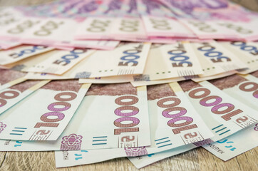 1000, 500 and 200 hryvnias on a wooden background. A lot of Ukrainian hryvnia. Money background.