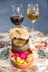 Georgian traditional food Lobio or kidney and haricot beans soup with picked vegetables and red wine.