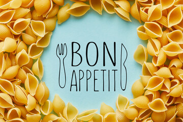 round frame of raw Conchiglie on blue background with bon appetit illustration