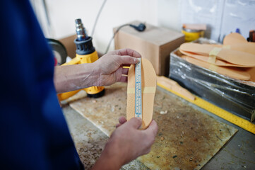 Prosthetist man making orthopedic insoles while working in laboratory.