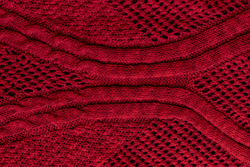 Dark red, burgundy knitted fabric texture. Rough sweater pattern background. Closeup view
