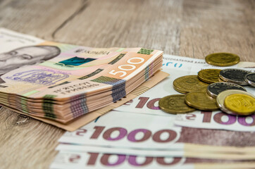 1000 and 500 hryvnia with coins on a wooden background. Close-up. Business concept.