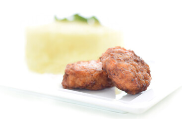 Meatballs with potato puree on white dish . High key food background