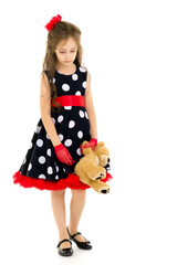 Upset Girl in Polka Dot Dress Standing with Teddy Bear