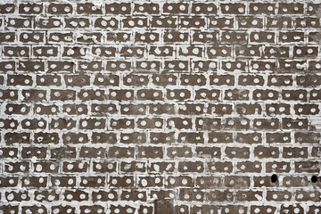 Adhesive residues of insulation panels on a house facade form a grid pattern on a demolition site.