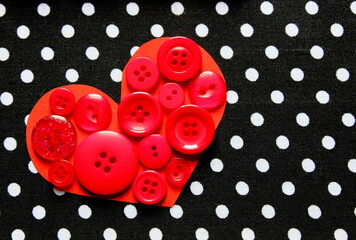 Romantic red heart made of red buttons on polka dot background