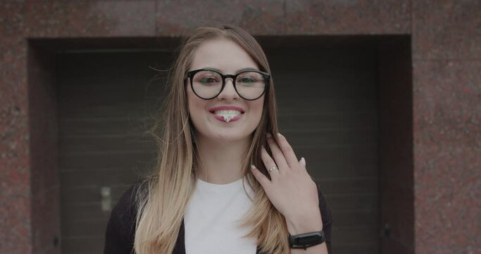 Hipster in glasses blows bubble of chewing gum and has fun with bursted it