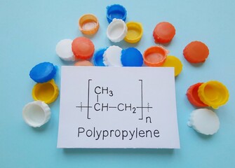 Polypropylene (PP, Polypropene) is a thermoplastic polymer, and it is produced via polymerization. Structural chemical formula of polypropene molecule with plastic bottle caps in the background.