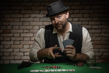 Poker player throwing play chips at the table -  poker in a dark back room with a brick wall
