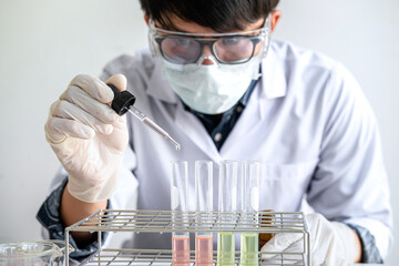 Biochemistry laboratory research, Chemist is analyzing sample in laboratory with equipment and science experiments glassware containing chemical liquid
