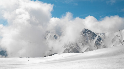 Snow mountain peak cover by cloud and blue sky