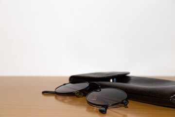 Glasses and brown case on a wooden table