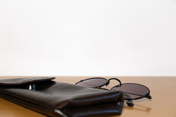 Glasses and brown case on a wooden table