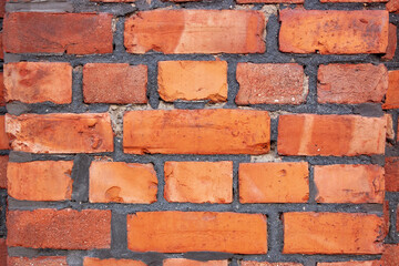 Obraz premium Old red brick wall. Bricks with individual texture with concrete layering .