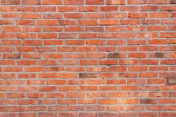 Old red brick wall. Bricks with individual texture with concrete layering .