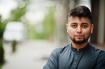 Сonfident pakistani indian muslim arabic boy in grey kameez shalwar suit.