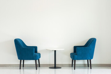 Blue turquoise double armchair with coffee table between armchairs in living room with copy space.