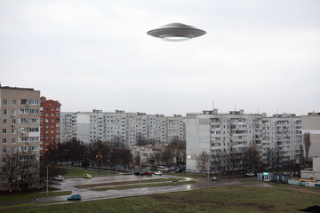 UFO flying in the sky over a city block. Photo with 3d rendering object 