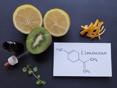 Structural chemical formula of limonene with fresh citrus fruit and a glass bottle of essential aroma oil. Limonene is the major component in the oil of citrus fruit peels. Beauty and spa products.