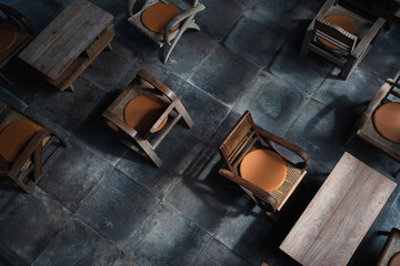Top view of wood tables and chairs in room on dark floor background