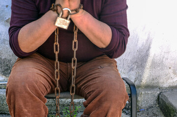 A man in chains, hands and feet.