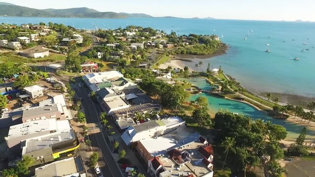 An aerial view shows Airlie Beach and its surrounding homes and roads.