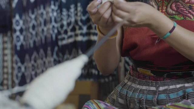 A Maya woman demonstrates textile manufacture with some raw cotton in Guatemala.