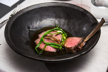 Juicy red meat of medium rare lamb chop with gravy