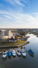Private neighborhood with lagoon in the middle. Large yachts are seen in its port.
