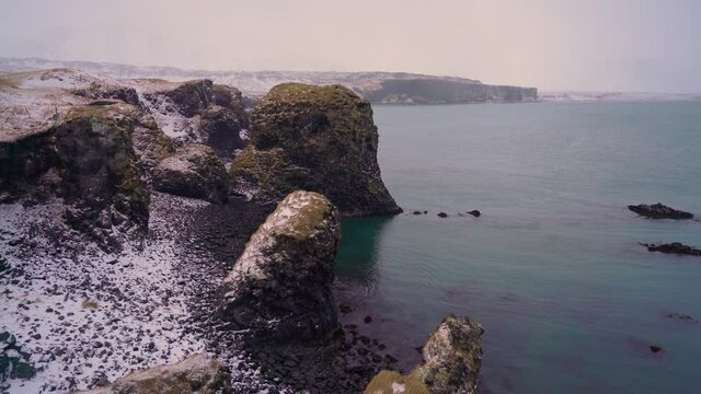 Snow is seen on the rocks of Arnarstapi Harbor on the Sn&aelig;fellsnes Peninsula of Iceland.
