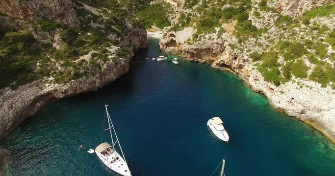 An aerial view shows sailboats and tourists at Stiniva Beach in Vis, Croatia.