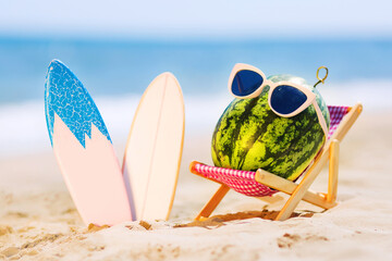Summer lifestyle image of attractive watermelon surfer lying on sunbed on the sand against...