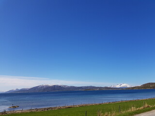 blue summer sea and snowy mountain view in northern Norway