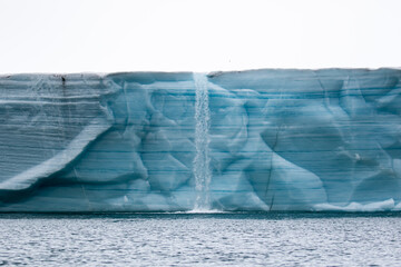 A water fall on the ice cliffs of Nordauslandet in Svalbard, in the Arctic