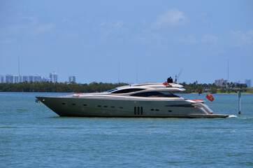 Luxury silver motor yacht idling on the Florida Intra-Coastal Waterway off Miami Beach.