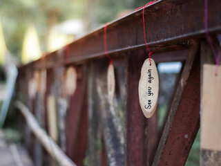 The text written in English "See you again" on a hanging piece of wood.