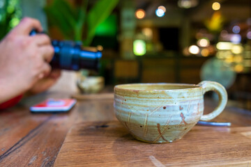 Close up ceramic cup of coffee on a wooden table 