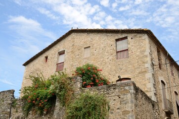 Fototapeta na wymiar Flowers on stone house in Besalu, Girona, Spain