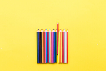 Colorful pencils on the yellow background outer space for text place